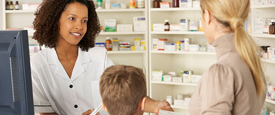 Pharmacist helping woman at cash register