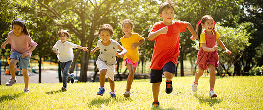 Group of kids running outside in the warm weather