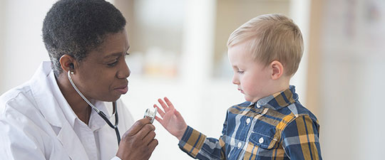 Doctor with stethoscope and toddler boy